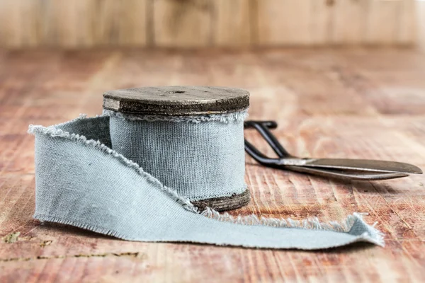 Oude spoelen van draad, stof, schaar op een houten achtergrond — Stockfoto