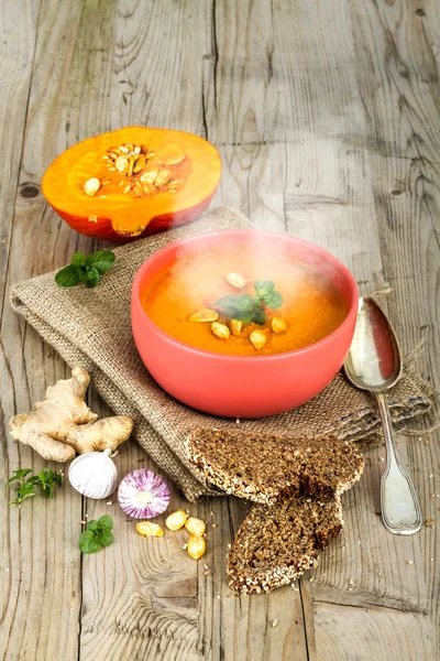 Pumpkin soup in bowl on vintage wooden background — Stock Photo, Image