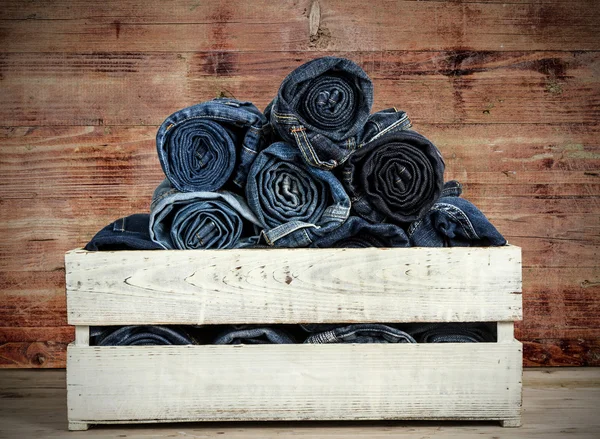Jeans azuis sobre fundo de madeira — Fotografia de Stock