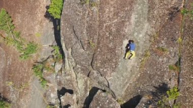 Cesur genç adam sigortasız kaya duvarına tırmanır.