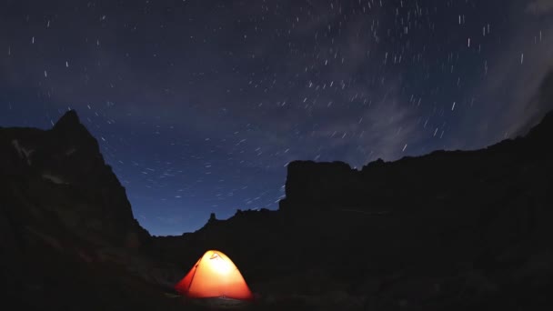 Tenda de laranja turística nas montanhas. Noite céu estrelado no Parque Natural Siberiano Ergaki — Vídeo de Stock