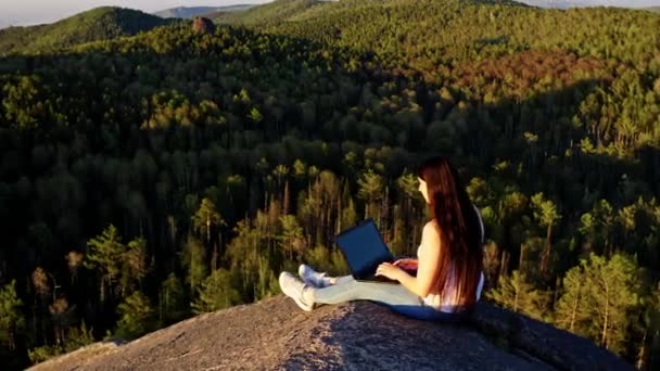 한 젊은 프리랜서인 반원형 파노라마 가 숲 속 산꼭대기에서 손을 위로 늘여 노트북을 만들고 있다. — 비디오