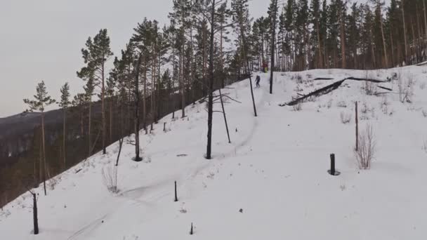 Een man gaat neer op ski 's van een bergtop. — Stockvideo