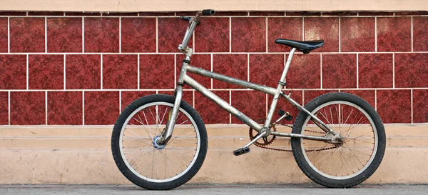 Bicicleta vieja estacionada en una pared — Foto de Stock
