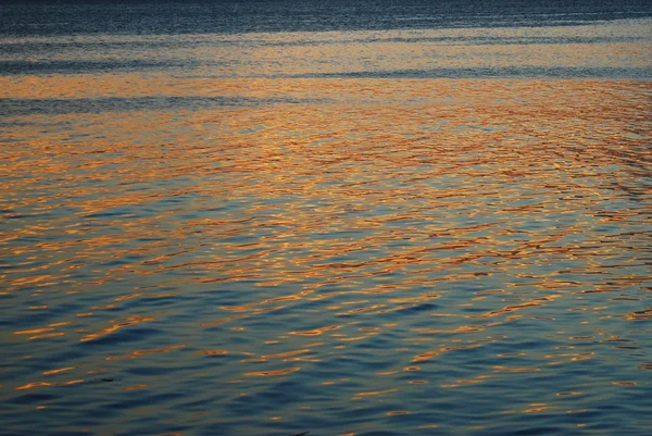 Reflexión al atardecer en la superficie de un mar tranquilo — Foto de Stock