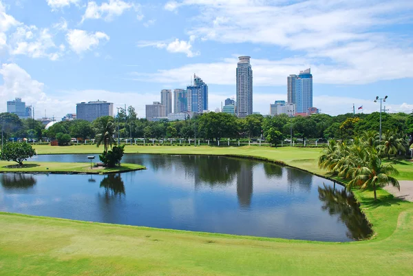 高尔夫球场绿化与城市背景 — 图库照片