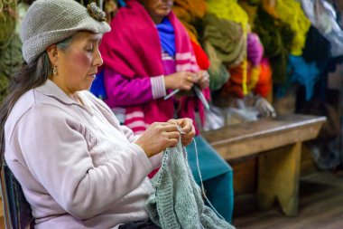 Guaranda, Bolivar, Ekvador - Kasım 2013: Bir tekstil imalatçısında kadınlar, satılık yün ürünleri dikiyor ve üretiyorlar.