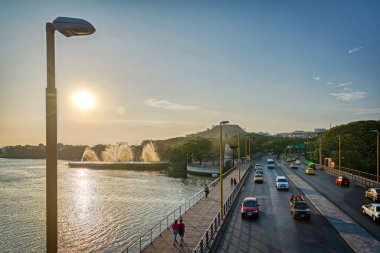 Guayaquil, Guayas, Ekvador - Kasım 2013: Puente del Velero 'dan (Yelkenli Köprüsü) Estero del Salado manzarası, gün batımında, bir çeşme, arabalar ve yürüyen insanlarla.