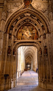 The Segovia Cathedral interior showcases towering Gothic arches and an ornate vaulted ceiling. Massive columns frame the central altarpiece and detailed stained glass