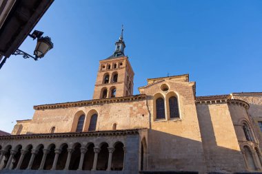 Romanesk-Mudjar tuğla kulesi ve San Martn Kilisesi kemerli portosu sıcak, öğleden sonra güneşiyle yıkanır, Segovia 'da parlak mavi bir gökyüzüne karşı.