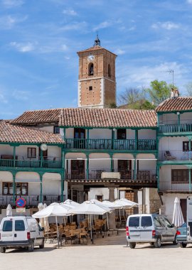 Çatıların tepesinde yükselen tuğla ve taş saat kulesi (Torre del Reloj) ile Chinchn 's Plaza Belediye Başkanı' nın ahşap balkon binalarını gösteren yüksek bir manzara
