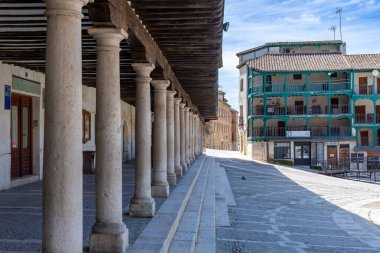 Chinchn 'in Plaza Belediye Başkanı' nın turkuaz ahşap balkonları ve ön planda ağır taş sütunları olan üç katlı kendine özgü binaları ön plana çıkaran manzarası..