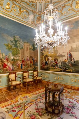 Madrid 'deki El Pardo Sarayı' nın şaşaalı iç mekanında tarihi kilimler, zengin kadife duvarlar, altın çerçeveli sanat eserleri ve boyalı bir tavanın altında antik kraliyet mobilyaları yer alıyor.