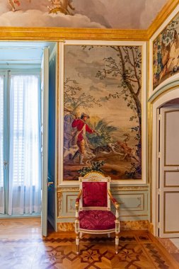 Madrid 'deki El Pardo Sarayı' nın şaşaalı iç mekanında tarihi kilimler, zengin kadife duvarlar, altın çerçeveli sanat eserleri ve boyalı bir tavanın altında antik kraliyet mobilyaları yer alıyor.