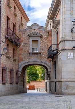 Madrid şehir merkezindeki taş ve tuğla kemer yolu dar bir sokaktan güneşli bir bahçeye uzanır, Plaza de la Villa yakınlarındaki Rönesans ve Barok tarzı iki binayı birbirine bağlar..