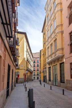 Uzun, geleneksel tuğla ve alçı binalar Madrid 'in merkezindeki eski kaldırımlı caddelerde, birden fazla katlı ve sıra süslemeli, işlenmiş demir balkonlar yer alıyor.