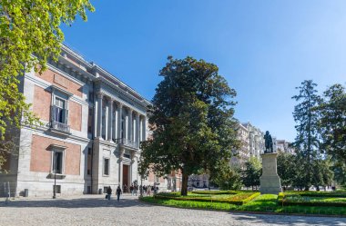 El Prado Museum on a sunny spring morning, showcasing elegant neoclassical architecture, grand statues, and lush green trees framing its bright, inviting faade with added charm