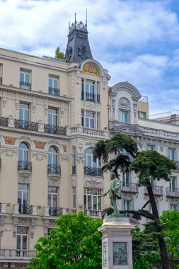 A typical street in central Madrid, lined with elegant historic buildings, balconies, and warm facades, capturing the citys lively charm and timeless architecture