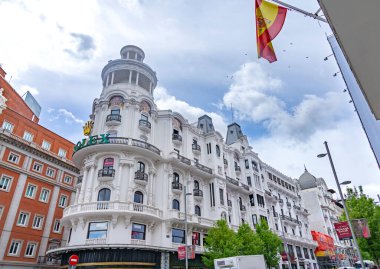 A decorative historic building in Madrid rises with curved lines, balconies, and detailed architectural features, creating a classic urban scene suited to many views