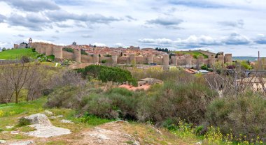 Görkemli vila duvarları üzerinde panoramik bir gözcü manzarası. Eski kasabanın kiremitli çatı ve kulelerini saran sayısız taş kuleler dramatik, bulutlu gökyüzü altında.