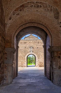 Puerta de Bisagra 'daki taştan kemerli kemerden Toledo, İspanya' daki güneşli bir avluya ve iç kapıya bakıyor. Antik tuğla ve taş ustası özellikleri