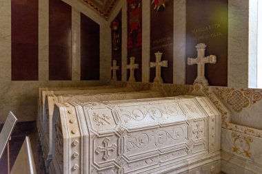 İspanyol prensleri ve prenseslerinin beyaz mermer lahitleri El Escorial 'da Bebeklerin Panteonu' nun içinde uzanır. Kırmızı mermer duvarlar ve yaldızlı sunak haçı bulunur.