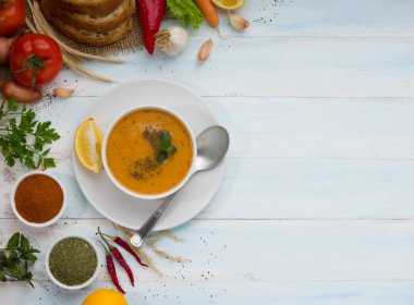 Geleneksel Türk mutfağı Tarhana Çorbası. Tahta masada sebzeli üst manzara. Yazı için yeri var.