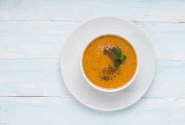 Geleneksel Türk mutfağı Tarhana Çorbası. Tahta masada sebzeli üst manzara. Yazı için yeri var.
