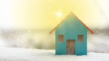 Minyatür mavi ahşap ev güneşte karlı