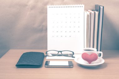 Masaüstü: telefon, kitap, cüzdan, kalp, eyeglasse yığını ile kahve