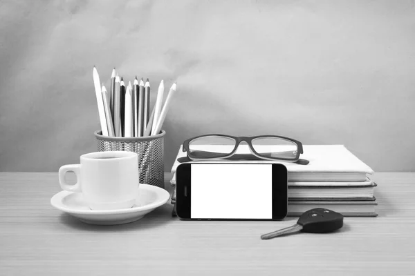 office desk : coffee and phone with car key,eyeglasses,stack of