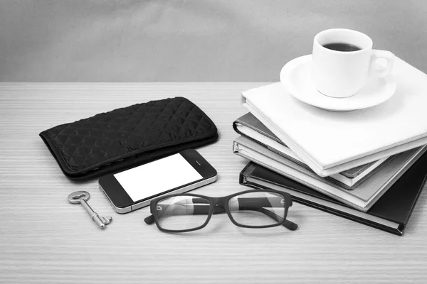 coffee and phone with stack of book,key,eyeglasses and wallet bl