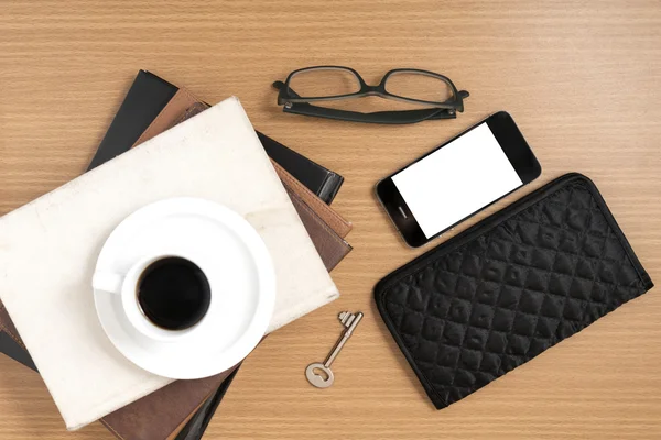 Koffie en telefoon met stapel boeken, sleutel, brillen en portemonnee — Stockfoto