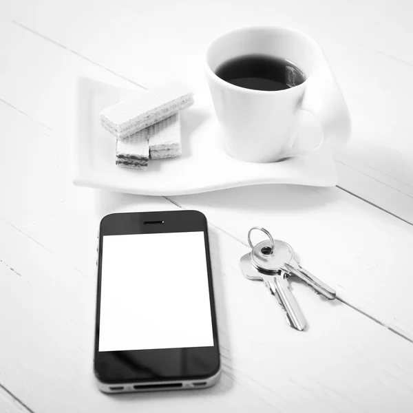 Чашка кофе с вафлей, телефон, ключ черно-белый цвет — стоковое фото
