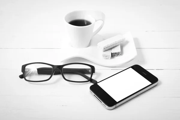 Kaffeetasse mit Hostien, Telefon, Brille schwarz-weiß — Stockfoto