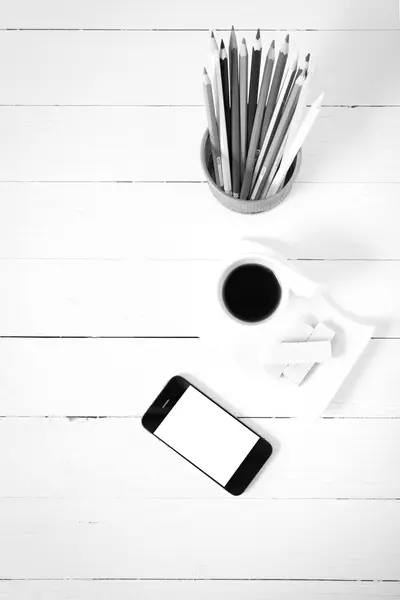 Tazza di caffè con wafer, telefono, scatola a matita colore bianco e nero — Foto Stock