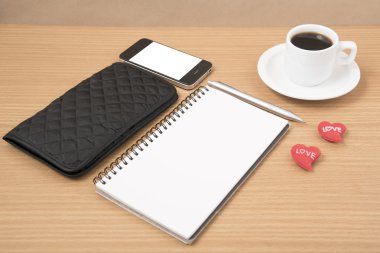 çalışma tablosu: telefon, not defteri, m-cüzdan ve kırmızı kalpli kahve