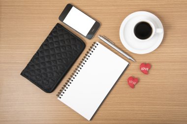 çalışma tablosu: telefon, not defteri, m-cüzdan ve kırmızı kalpli kahve