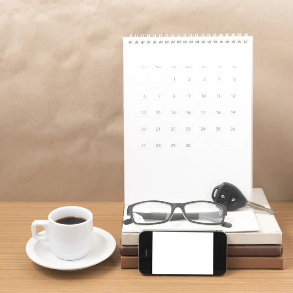 Kaffee und Telefon mit Autoschlüssel, Brille, Stapel Bücher, Kalender — Stockfoto