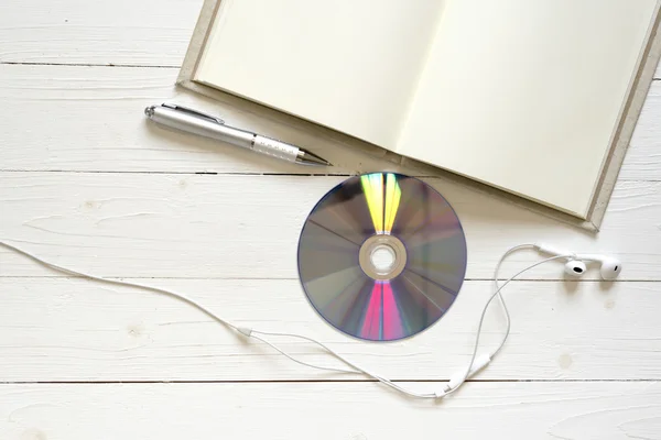 Top view of notebook dvd disc and earphone — Stock Photo, Image