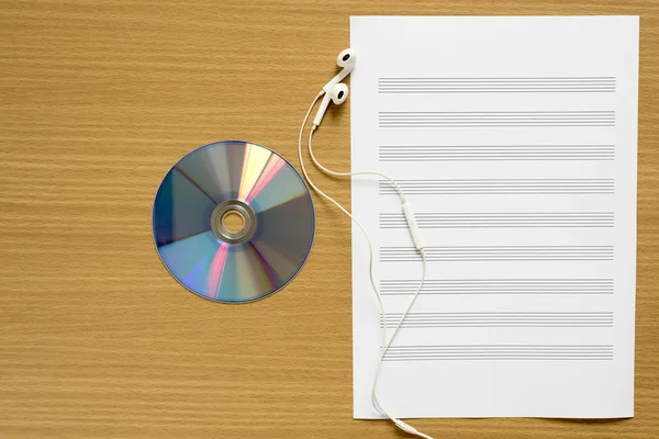 Tilikan atas dari staf musik dvd piring kertas dan earphone — Stok Foto