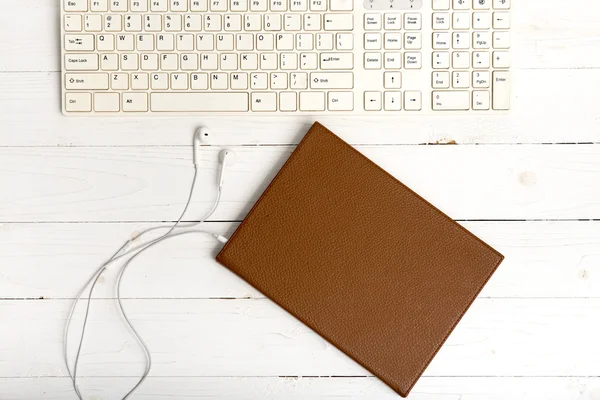 Top view of keybard computer with notebook and earphone — Stock Photo, Image