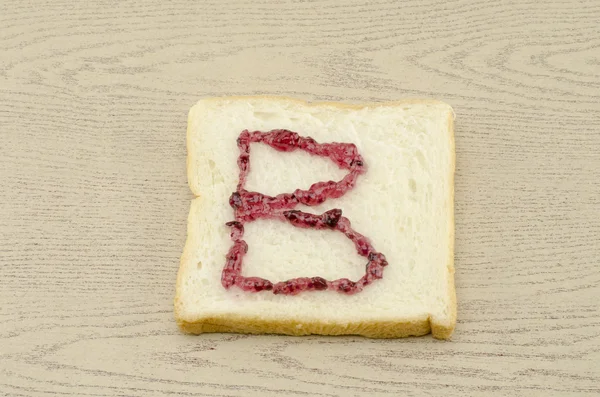 Jam alphabet on sliced bread — Stock Photo, Image