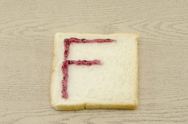 Jam alphabet on sliced bread — Stock Photo, Image