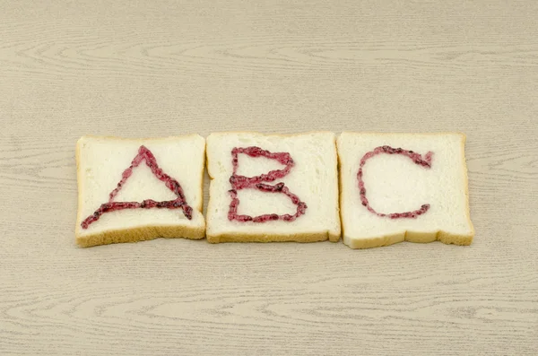 Jam alfabetet på skivat bröd — Stockfoto