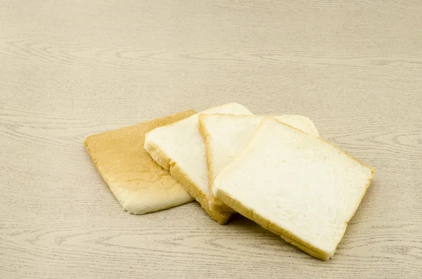 Krojonego chleba na brązowy drewno — Zdjęcie stockowe