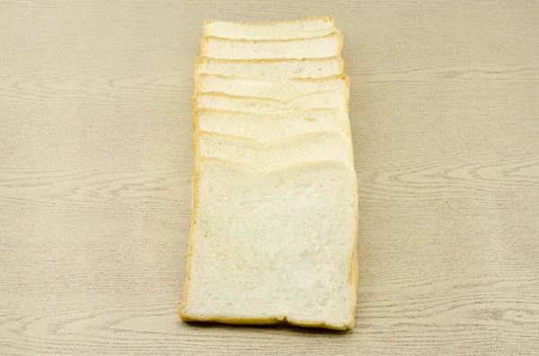 Sliced bread on brown wood — Stock Photo, Image