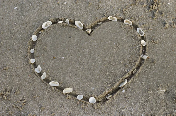 Et hjerte i sanden på stranden – stockfoto