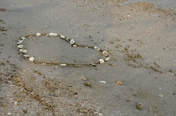Сердце на песке на пляже — стоковое фото