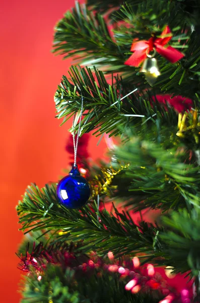 Albastru minge de Crăciun pe copac pe fundal roșu — Fotografie, imagine de stoc